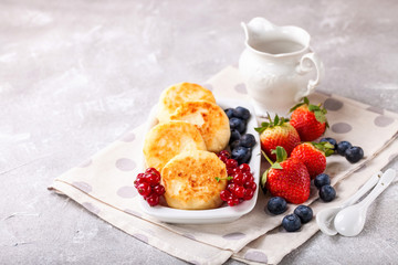 Wall Mural - Cottage cheese pancakes with berries. Selective focus. Russian cheesecakes. Copy space