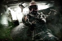 Heavily Armed Masked Paintball Soldier On Post Apocalyptic Background. Ad Concept.