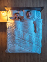 Wall Mural - The man snore near the wife on the bed. evening night time. view from above