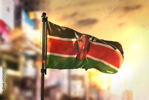 Fotografie, Obraz Kenya Flag Against City Blurred Background At Sunrise Backlight