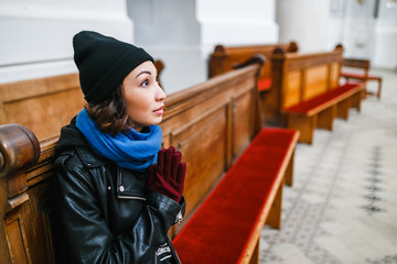 Young faithful woman praying in the church