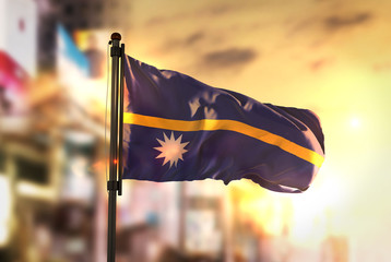 Wall Mural - Nauru Flag Against City Blurred Background At Sunrise Backlight