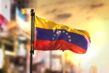 Venezuela Flag Against City Blurred Background At Sunrise Backlight