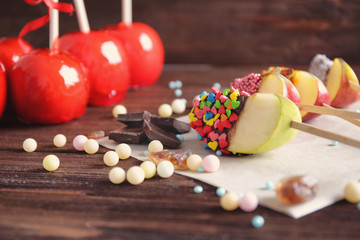 Poster - Toffee apples and candied wedges on wooden background