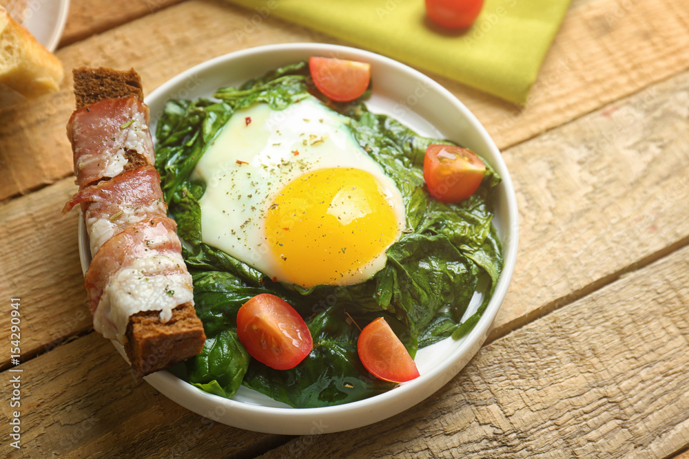 Delicious eggs Florentine with tomatoes on kitchen table