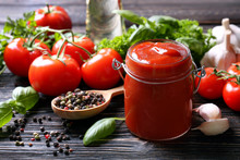 Composition Of Ketchup In Jar And Ingredients On Wooden Background, Closeup