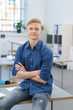 © contrastwerkstatt - selbstbewusster junger mann sitzt im büro auf dem schreibtisch