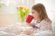 © spass - Pretty sick little child girl laying in bed drink tea