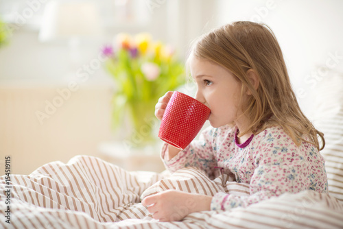 Fotografia Pretty sick little child girl laying in bed drink tea