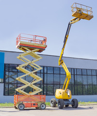 Scissor and articulated boom wheeled lifts on asphalt ground