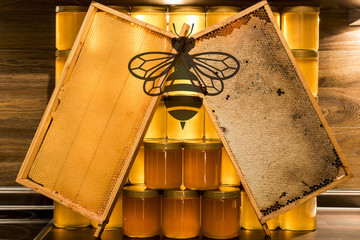 Golden yellow honey glass jar on wooden board Closeup Copy space comp frame empty and filled with bee logo textspace