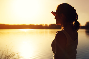 Silhouette of young woman watching sunset nature