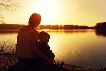 Wall Mural - Silhouettes of mother and her son watching sunset