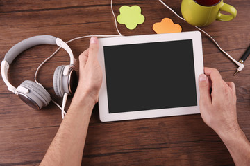 Poster - Audio book concept. Young man using tablet and headphones, close up