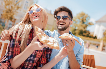 Couple eating pizza outdoors. Dating, consumerism, food, lifestyle concept