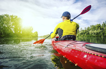 A Man Rafts On A Kayak On The River In A Sunny Day.
