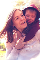 Wall Mural - Smiling mother and child playing together in park