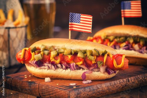 Plakat Amerykański hot dog z marynatami, cebulą, keczupem, musztardą i frytkami na pikniku w dniu 4 lipca
