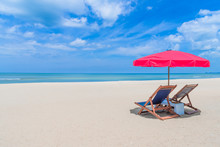 Beach Chair With Red Umbrella On Tropical Beach In Blue Sky.