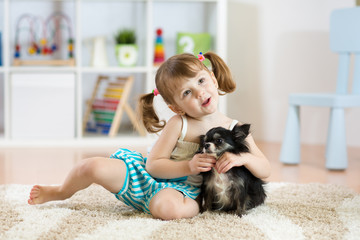 Wall Mural - Lovely little girl playing with her pet dog