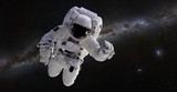 Fototapeta Kosmos - Astronaut in front of the Milky Way galaxy