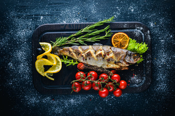 Wall Mural - Trout fish baked with aromatic herbs and spices. On Wooden background.