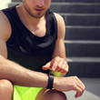 Smartwatch fitness man touching sports watch before running on stairs workout. Closeup of wrist and hand.