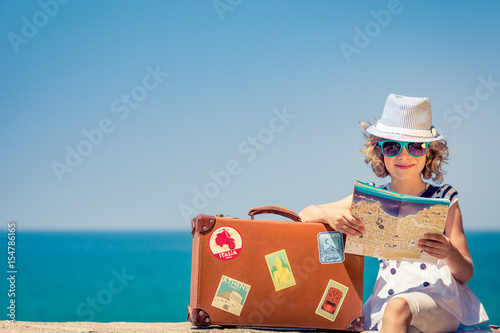 Child with vintage suitcase on summer vacation