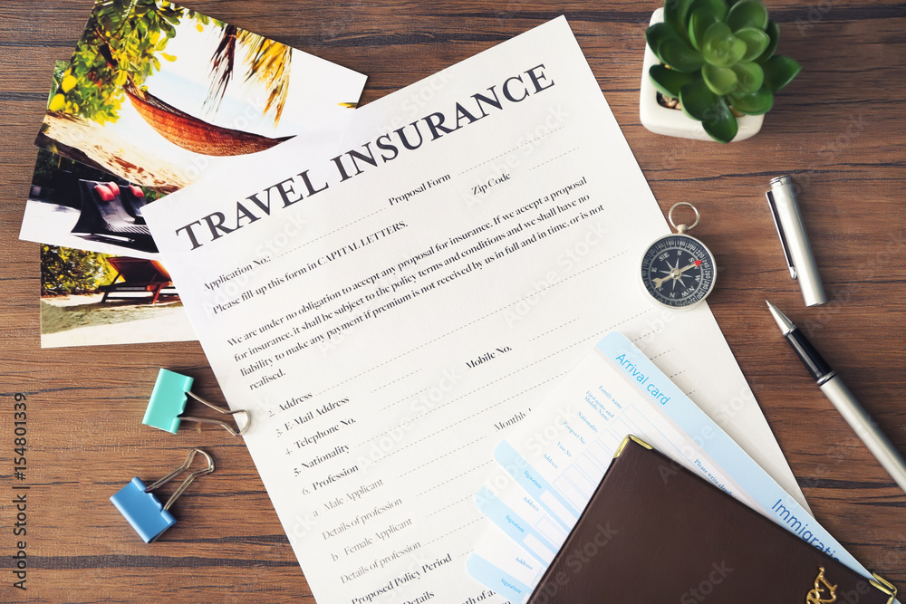 Blank travel insurance form on wooden background, closeup