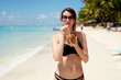 © Dusan Petkovic - Sexy young woman drinking coconut cocktail on the beach. Sunbathing on a sunny ocean shore.