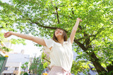 Fototapeta Nowy Jork - 若い女性　新緑の公園で背伸びをするイメージ