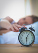 © lenets_tan - Young sleeping woman and alarm clock in bedroom at home
