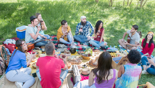 Zdjęcie XXL letni piknik z różnorodnymi przyjaciółmi w jasny słoneczny dzień w pięknej zielonej trawie w parku