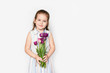 © Shcherbakova - smiling little girl with a bouquet of tulips