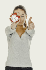 Woman with a clock and thumbs up.