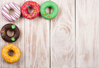 Wall Mural - glazed donuts on a white wooden background with copy space for your text. Top view