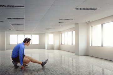 Poster - Fitness asian man stretching his legs after running exercise