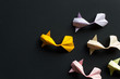 Handmade paper craft origami gold koi carp fishes on black background.Top view, pattern
