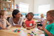 © Monkey Business - Teacher And Pupils Using Wooden Shapes In Montessori School