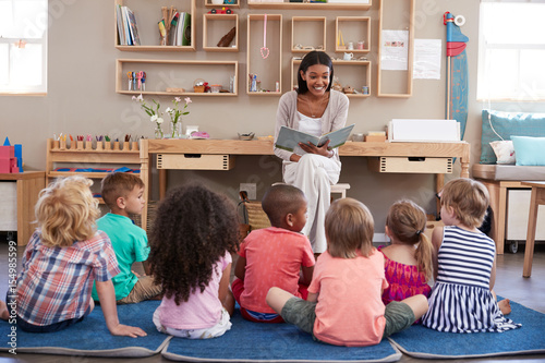 Fotografía Teacher At Montessori School Reading To Children At Story Time