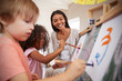 © Monkey Business - Teacher At Montessori School Helping Children in Art Class