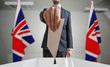 Election or referendum in Great Britain. Voter holds envelope in hand above ballot. United kingdom flags in background.