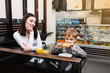 © aemstock - Mom with a small son is sitting in a cafe, drinking juice and eating sweets