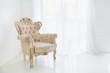 Vintage antique armchair against window with curtains in white room