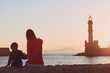 family looking at lighthouse in Greece at sunset
