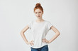 © Cookie Studio - Pretty girl with ginger hair looking at camera with arms akimbo.