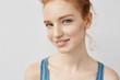 Closeup portrait of beautiful redhead girl with freckles smiling looking at camera.