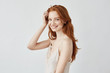© Cookie Studio - Beautiful redhead model with freckles smiling looking at camera.