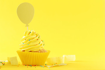 Wall Mural - Tasty cupcake on a yellow background