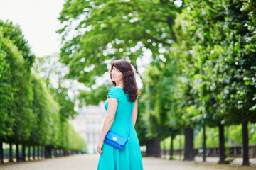 Wall Mural - Beautiful young woman walking in Parisian Tuileries park